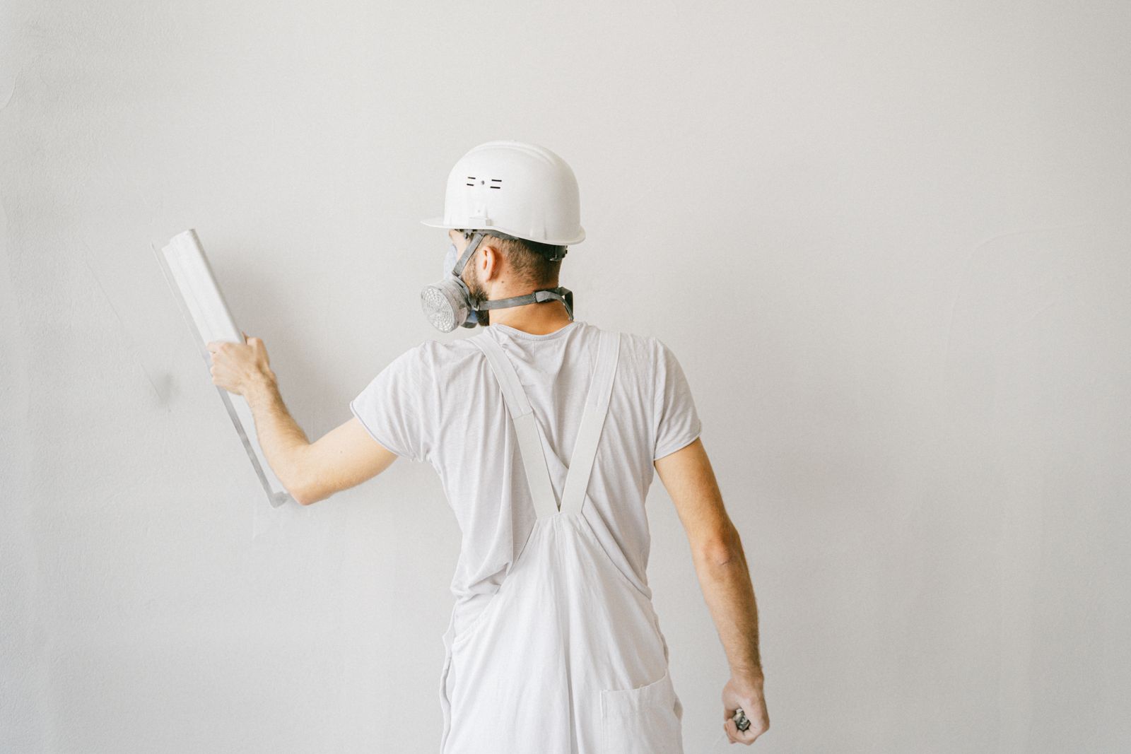 AGCentury Drywall crew finishing a freshly taped, paint-ready interior wall on a clean job site.